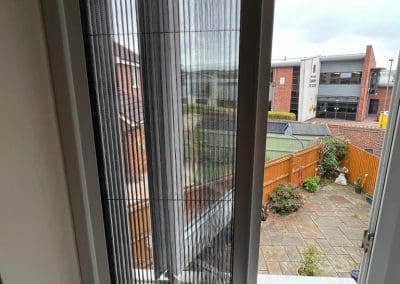 Best Fly Screens - Fly Screen fitted reveal on French double doors. The screen is half closed.